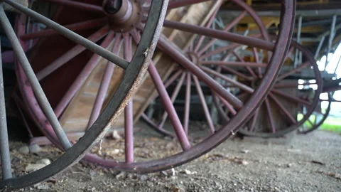 Close-up of a 19th century Shaker Amish wooden wagon wheel in a barn Stock Footage 159793774