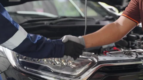 Close up of 2 mechanic hands in gloves making handshake in front of a car Stock Footage 246118822