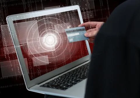 Close up of 3D hacker's hand using a laptop while holding a credit card 写真素材