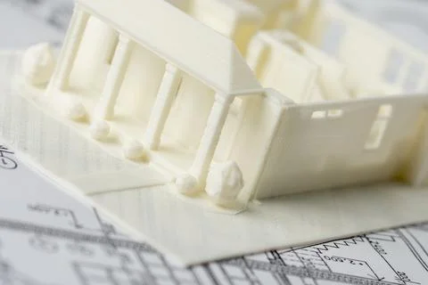 Close-up of 3D model of the house printed on a 3D printer with white filament by Stock Photos