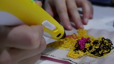 Close-up of 3D pens in the hands of a child. The child draws with a 3D pen. Stock Footage 229418727