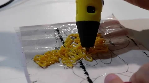 Close-up of 3D pens in the hands of a child. The child draws with a 3D pen. Stock Footage 229418738