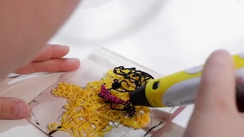 Close-up of 3D pens in the hands of a child. The child draws with a 3D pen. Stock Footage 229418916