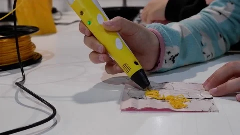 Close-up of 3D pens in the hands of a child. The child draws with a 3D pen. Stock Footage 229419071