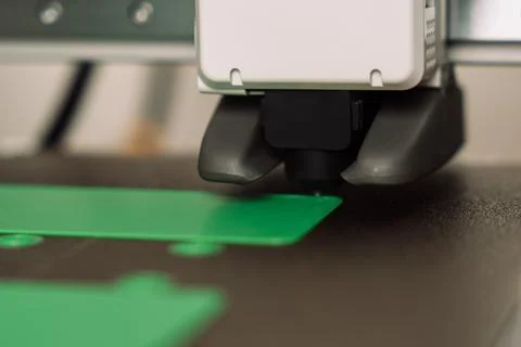 Close-up of 3D printer extruder printing green plastic object on heated build Foto stock
