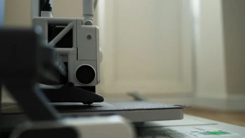 Close-up of 3D printer nozzle moving across build plate, creating intricate Видео 339182731