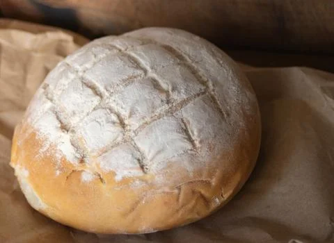 Close-up at 45 degrees of a loaf of bread on rustic paper. Stock Photos