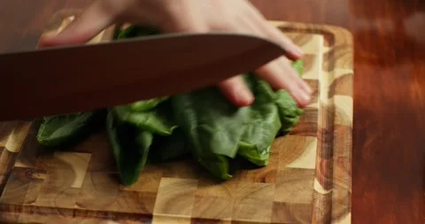 Close-up 4K: Chef cutting fresh spinach on wooden cutting board, on wooden table Stock Footage 317187698