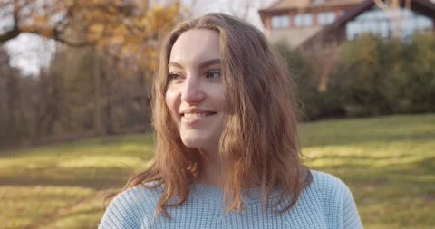 Close up 4k portrait of young pretty curly brunet female in autumn park Stock Footage 144979761