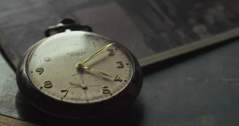 Close up 4K of ticking second hand on vintage watch over photographs Stock Footage 332634190