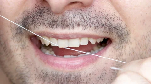 Close up 4k video young man mouth,smiling and flossing teeth Video stock 197058629