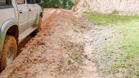 Close up of 4x4 SUV tire spinning in deep mud with heavy splash. Cinematic .. Stock Footage 337805935