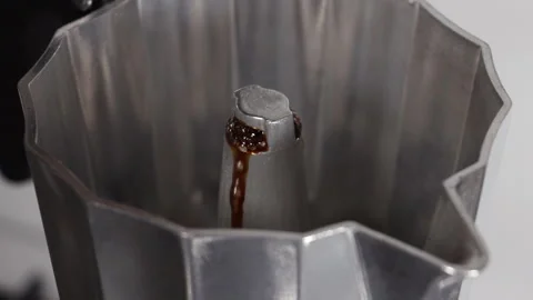 Close up from above coffee start coming out of Italian coffee maker slow motion Stock Footage 263058723