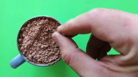 Close-up from above of a hand dissolving cocoa lumps in a cup of milk. Stock Footage 237192306