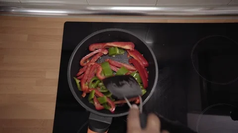 Close-up from above of hand removing vegetables on glass ceramic hob Video stock 252084762