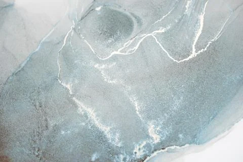 Close-up abstract image of silver veins swirling in a calm ocean blue liquid Stock Photos
