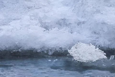 Close-up abstract view of textured ice formations on a dark water surface Stock Photos