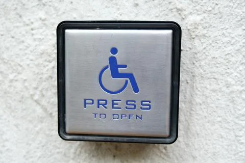 Close-up of a accessibility push button with a wheelchair symbol Stock Photos