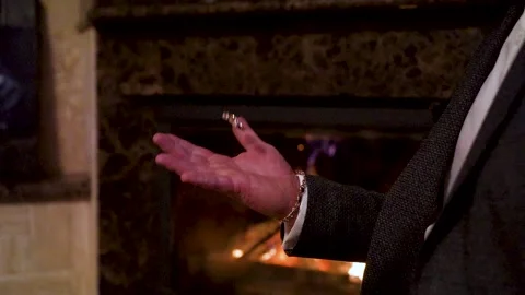 Close up accessories. Man throws wedding rings. Slowmotion. Fireplace background Video stock 202281985