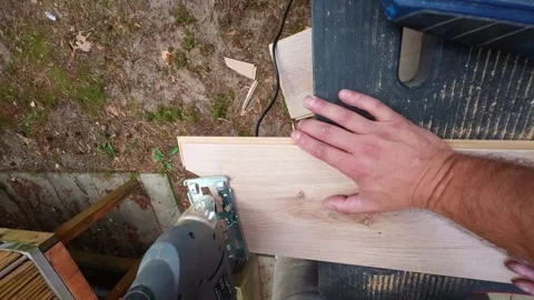 Close-up action of cutting wood laminate flooring with power jigsaw in garden Stock Footage 341076562