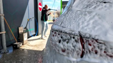 Close Up of Active Foam on Car with Man Blurry Background Fotos de archivo