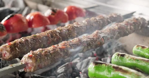 Close-up Adana kebab grilling with vegetables on barbecue charcoal grill. Smoke Stock-Footage 286342117