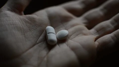 Close-up addicted man's hand with opioid pills on a dark background. Stock-Footage 225864705
