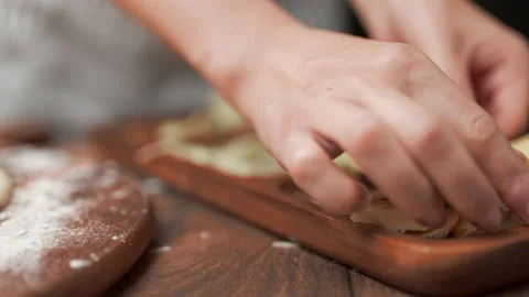 Close-up adding cheese on top of the pizza in slow-motion in 4K. Stock Footage 137484502