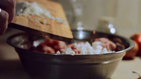 Close-up of adding cut onion to minced meat in metallic bowl. Process of Stock Footage 144822048