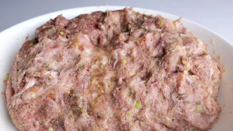 Close-up of adding egg to fresh minced meat Stock Footage 147740382