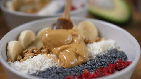 Close up of adding peanut butter to the organic yummy creamy plant based Stock Footage 157411828