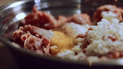 Close-up of adding salt and black pepper to minced meat in metallic bowl Stock Footage 144822518