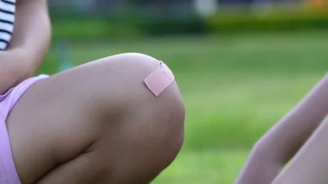 Close Up Of Adhesive Plaster On Child Scraped Knee Stock Footage 345555327