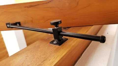 Close-Up Adjustable Black Metal Window Stay Bar on Wooden Frame Fotos Stock