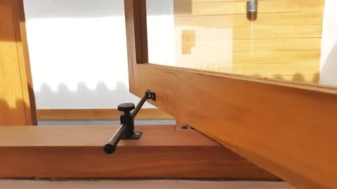Close-Up Adjustable Black Metal Window Stay Bar on Wooden Frame Stock Photos