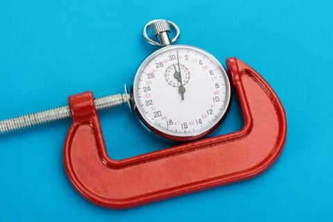 Close-up Of Adjustable Clamp And Stopwatch Over Blue Background Stock Photos
