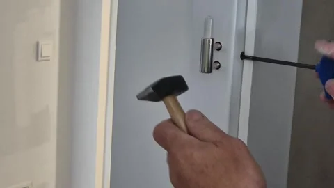 Close Up of Adjusting Door Hinge with Hammer and Screwdriver Stock Footage 335709874