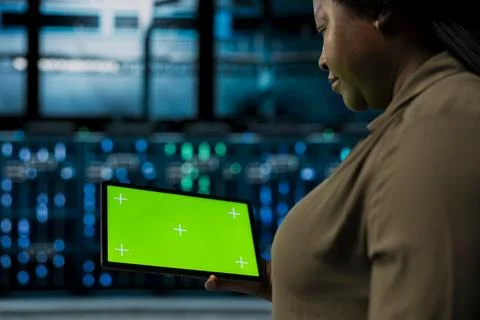 Close up of admin holding green screen tablet walking through server room Stock Photos