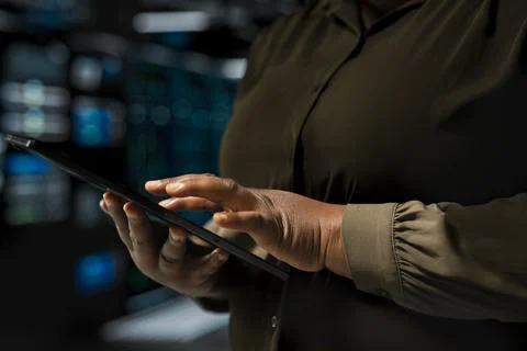 Close up of admin holding tablet walking through server room rows Foto stock