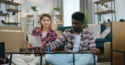 Close up of adorable happy smiling young multiethnic couple which sitting both Stock Footage 158569111