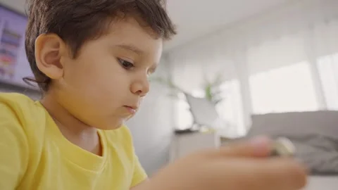 Close up adorable small child sitting on floor playing with smartphone at home Stock Footage 245728947