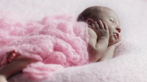 Close up of adorable tiny newborn baby girl sleeping on a pink knitted blanket i Stock Footage 50154930