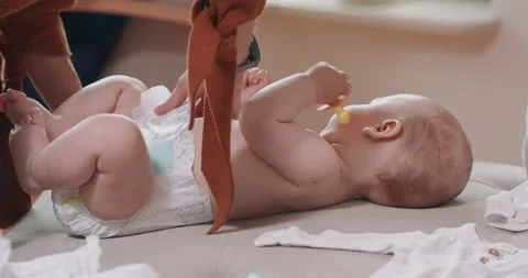 Close up of an adrorable baby, lying on its back on the couch, holding a Stock Footage 140181768