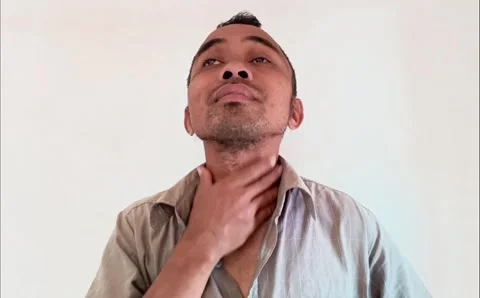 Close-up of an adult man checking his throat by touching his neck. Stock Footage 321940752