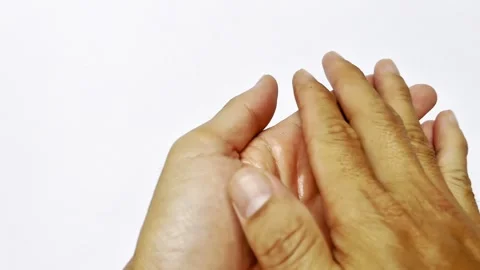 Close-up of an adult man's hand using hand sanitizer on a white background 库存影片 338365009