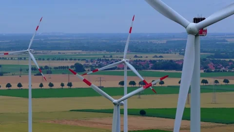 Close Aerial Flyby of Rotating Wind Turbines Over Farmland Stock Footage 340137286