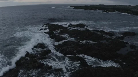 Close aerial on ocean waves splashing on rocks 動画素材 243668767