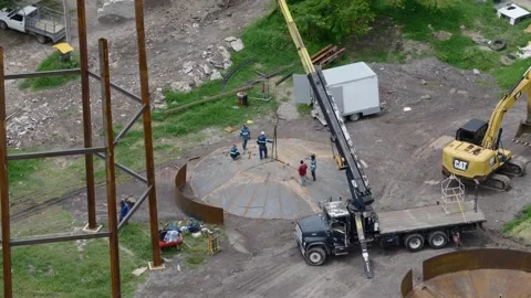 Close aerial orbit of workers assembling a steel water storage tank in Tuxpan Stock Footage 346810269