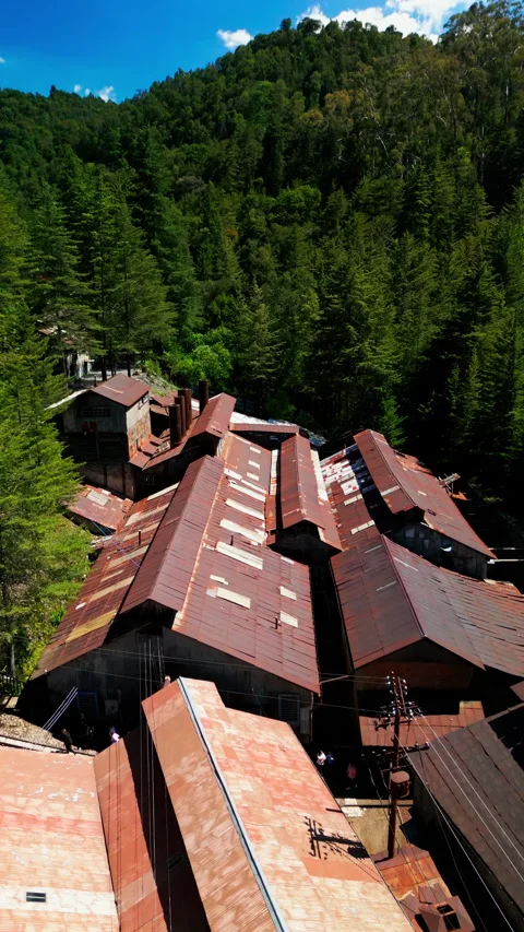 Close aerial pass over the corrugated and tiled roofs of the Mina Dos Stock Footage 346015614