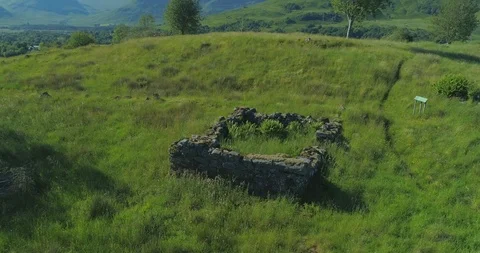 Close up aerial passover of neolithic stone house by forest ruins near Dalmally 스톡 동영상 115499149